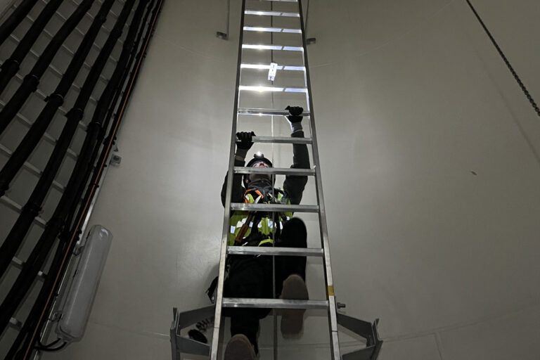 Man climbing up a wind turbine tower